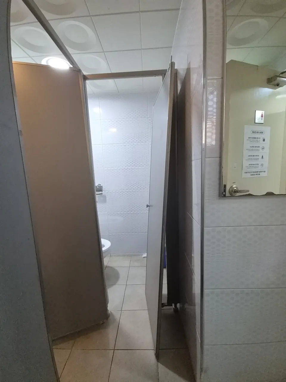 빌딩화장실큐비클수리 문이 열려 있는 흰 타일 화장실 칸막이