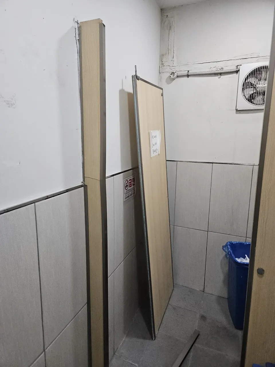 화장실큐비클깨진판교체 분리된 패널이 벽에 세워져 있는 교체 작업 현장